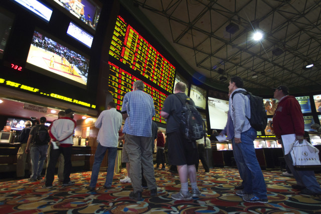 People wait in line to place bets on Super Bowl XLVIII at the Las Vegas Hotel & Casino Superbook in Las Vegas, Nevada Jan. 23, 2014.