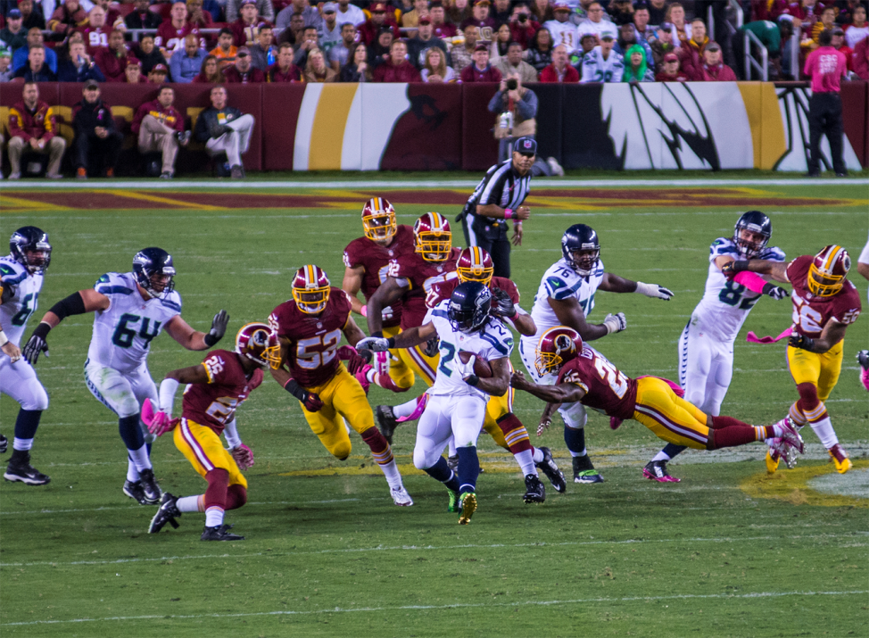 The defending team, the Washington Redskins, tries to stop the offense of the Seattle Seahawks from moving the ball down the field. (VOA / Frank Mitchell)