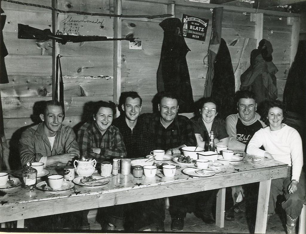 A group of deer hunters sit down for dinner in 1943 at a hunting cabin in Florence County, Wisconsin. Photo courtesy Wisconsin Department of Natural Resources, via Flickr)