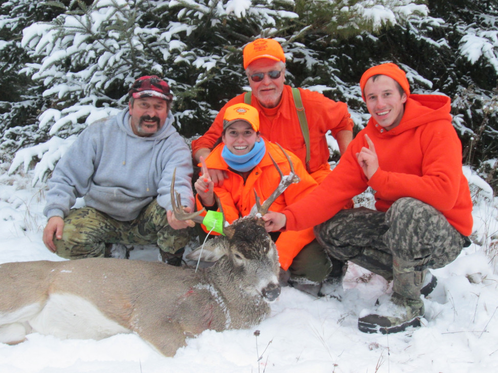 A hunter poses with her first deer. With her are  her father, grandfather and cousin – three generations of hunters. (Photo courtesy Wisconsin Department of Natural Resources, via Flickr)