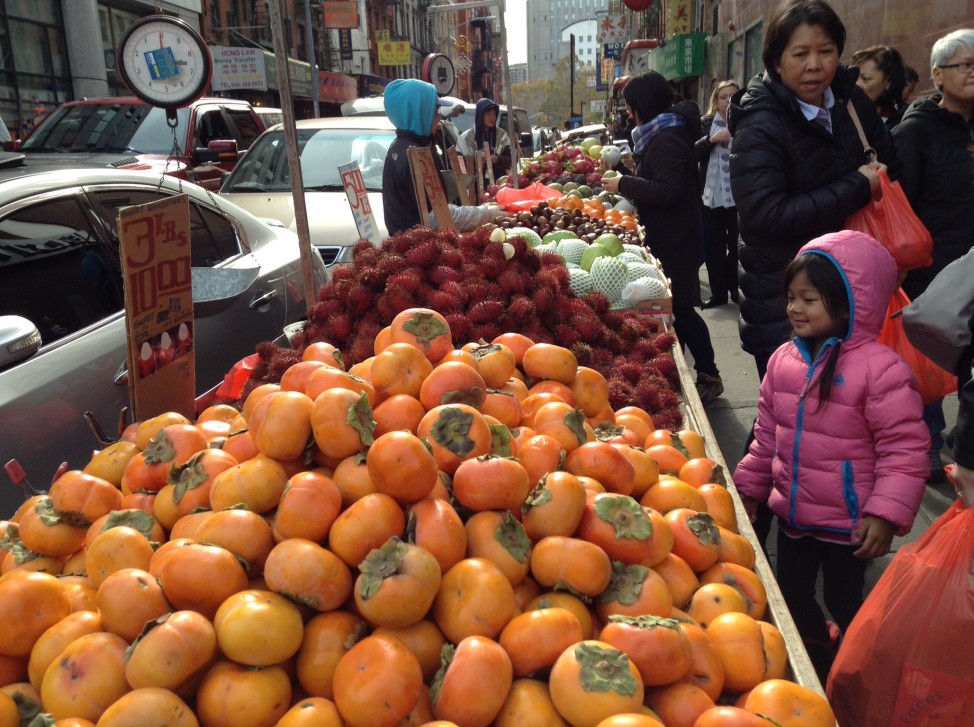 A fruit seller in New York's Chinatown. After English and Spanish, Chinese is the most commonly spoken language in the state.