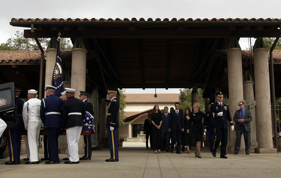 The casket carrying the body of former President Ronald Reagan is loaded into a hearse as Nancy Reagan and her family are escorted from the Ronald Reagan Presidential Library in Simi Valley, California, June 9, 2004. (AP Photo)