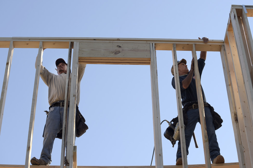 In this Feb. 13, 2015 photo, construction workers David Rager, right, and Shawn White frame the upper floor of a two-story custom home being built in Orlando, Florida. (AP Photo)