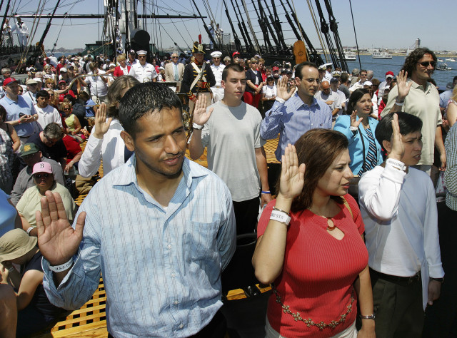 (File Photo) From left, Juan Quiroz, Rita Daaboul and Le Minh Le, take the oath of citizenship during a Naturalization ceremony aboard the USS Constitution, on the annual Fourth of July turnaround cruise in Boston Harbor. (AP Photo)