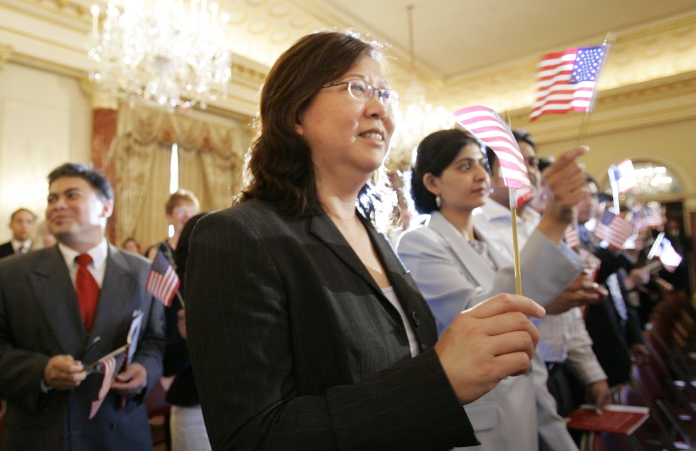 FILE - Ying Fang Kaplan from Taiwan, center, Anju Vajja from India, right, and Alfred Tecson from the Philippines, left, wave the American flag after being sworn-in as new citizens of the United States at the State Department in Washington, D.C. (AP Photo)