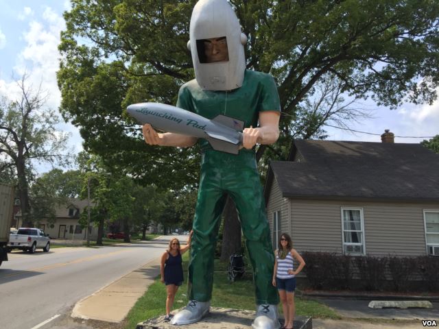 VOA reporters Caty Weaver (left) and Ashley Thompson (right) with the Gemini Giant in Wilmington, Illinois