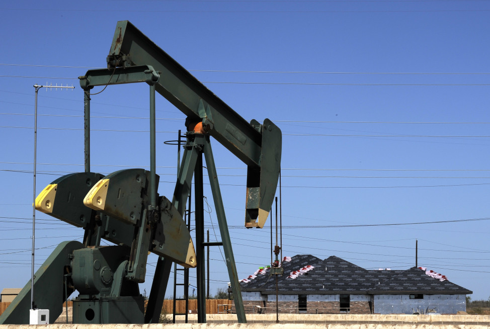In this Monday, Sept. 23, 2013 photo, a pump jack works beside the site of new home construction, in Midland, Texas. (AP Photo)