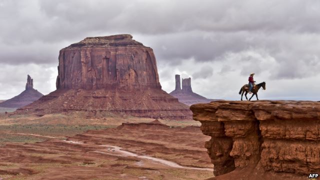 A Navajo man on a horse poses for tourists in front of the Merrick Butte in Monument Valley Navajo Tribal Park, Utah, in May 2015. (AFP PHOTO)