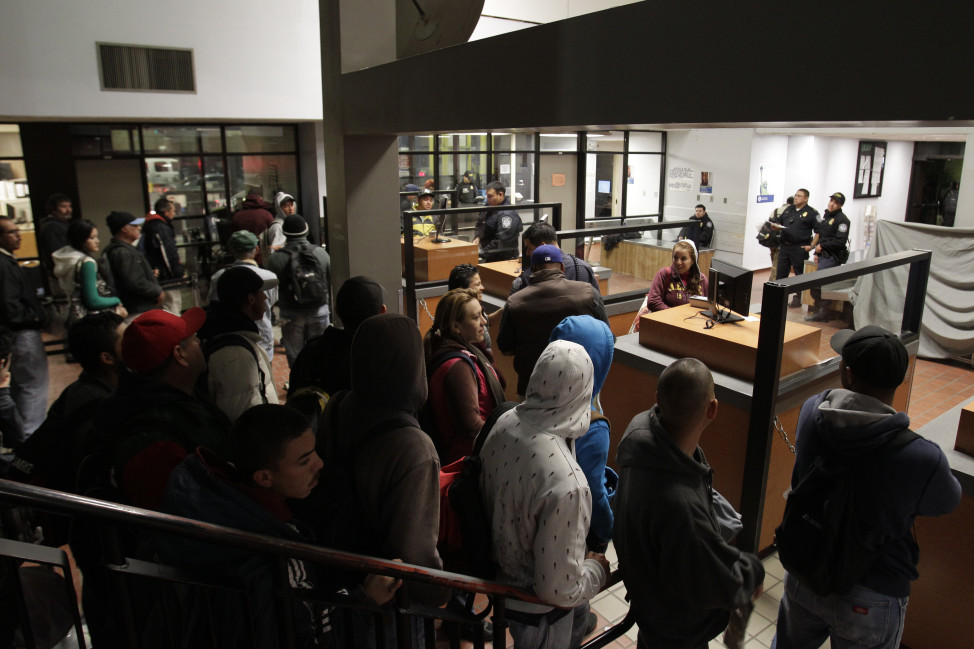  In this Feb. 1, 2012 file photo, people line up to cross into the United States from Mexicali, Mexico, before dawn in Calexico, California. 