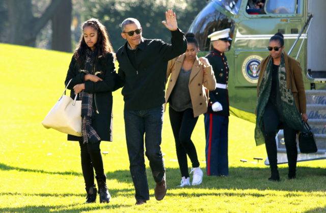 U.S. President Barack Obama waves as he walks with first lady Michelle Obama (R) and their daughters Malia (L) and Sasha on the South Lawn of the White House in Washington January 3, 2016. The Obama family returned from Hawaii, the president's home state, after concluding a 15-day holiday vacation. REUTERS/Yuri Gripas - RTX20VWO