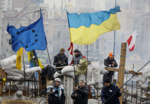 Ukrainian pro-EU demonstrators wave EU and Ukraine flags at a barricade in Independence Square in Kiev