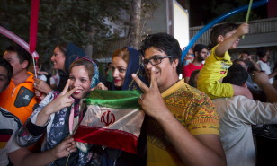 Iranians gesture as they celebrate in the street following a nuclear deal with major powers, in Tehran