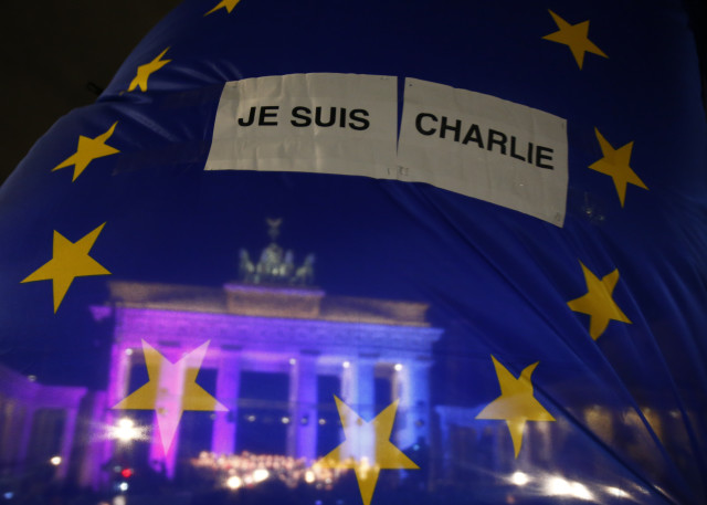 The Brandenburg Gate is seen through EU flag during a vigil  for the victims of Paris attacks in Berlin