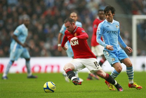 David Silva na Manchester City (dama) yana kokarin kwace kwallo daga kafar Wayne Rooney na Manchester United a karawar da suka yi na gasar cin Kofin FA a filin wasan Etihad dake birnin Manchester, Ingila, ran Lahadi 8 Janairu 2012. 