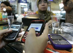 Penjual BlackBerry di sebuah pusat perbelanjaan di Jakarta sedang memeriksa barang dagangannya (foto: AP).