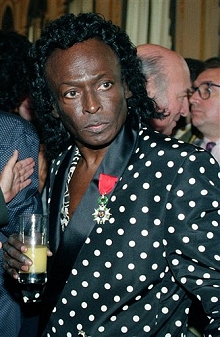 Miles Davis holds a glass of orange juice after receiving the Chevalier de la Legion d'Honneur award medal in Paris from the French government, July 16, 1991