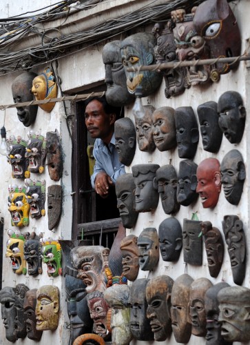 A Nepalese shopkeeper looks out from his shop at Basantapur Durbar square in Kathmandu. The Durbar Square, which holds the palaces of the Malla and Shah kings who ruled over the city, is located in the center of the capital and is listed as a UNESCO world heritage site. (AFP)