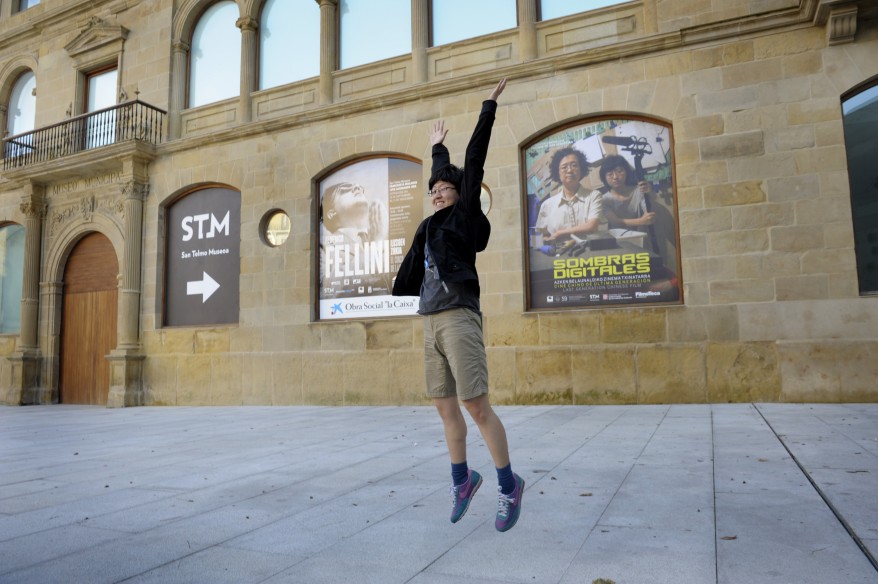 Chinese director Liu leaps in front of a poster for "Digital Shadows: Last Generation Chinese Film" at the San Sebastian Film Festival. (Reuters)
