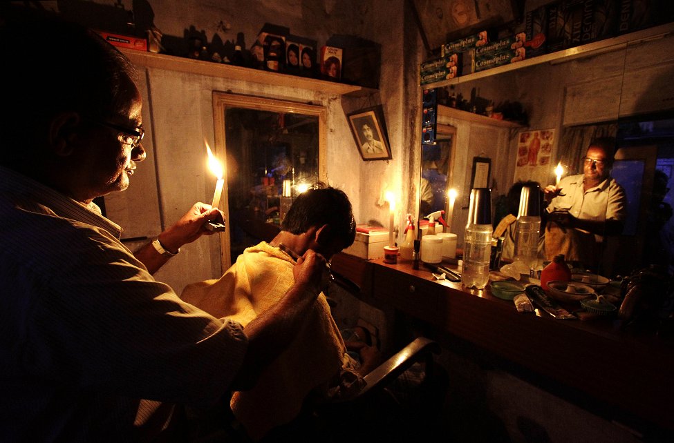 印度停电，理发师只好手持蜡烛服务顾客