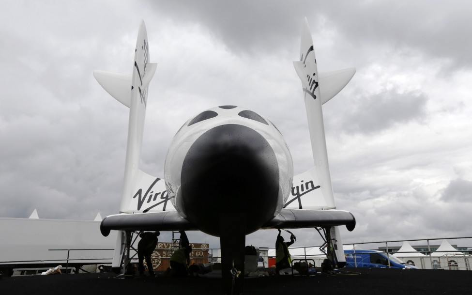 Workers prepare Virgin Galactic's SpaceShipTwo ahead of the Farnborough Airshow 2012 in southern England, July 7, 2012. (Reuters)