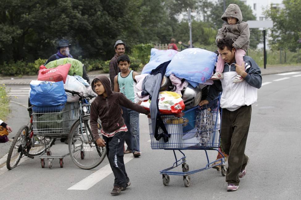 法国北部吉普赛流浪家庭用购物车推着家当转移，搬出非法营地。法国警方从该营地驱离了150人。