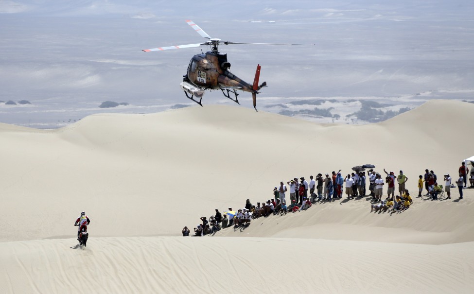 2013年1月5日达喀尔多种车辆越野拉力赛第一阶段，从秘鲁利马尔到皮斯科。图为西班牙摩托车车手穿过沙漠。(路透社)