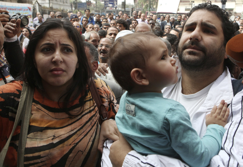 Alaa Abdel Fattah (R), one of the activists who was summoned by the public prosecutor on whether he had a role in the recent violent anti-Islamists protests, arrives with his wife and child to the public prosecutor's office in Cairo, March 26, 2013. Fattah was arrested November 28 on charges he violated Egypt's new anti-protest laws. REUTERS/Asmaa Waguih