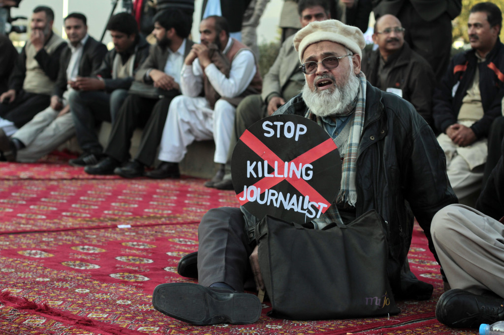 A journalist holds a placard while taking part in a demonstration in front of the Parliament building in Islamabad January 28, 2013. Journalists from all over the country held a demonstration on Monday against a recent spate of killings of journalists and demand compensation for the deceased. REUTERS/Faisal Mahmood