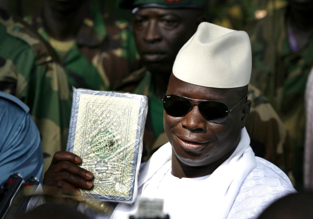 Gambian President Yahya Jammeh holds up a Koran while speaking to the media  after casting his ballot in the presidential elections in Banjul September 22, 2006. REUTERS/Finbarr O'Reilly 