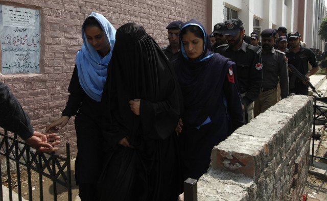 Police escort Salma alias Fatima (dressed in black), 40, who was arrested under the blasphemy law, as she leaves after appearing in the district court in Lahore September 17, 2013. Upon the allegations of the Imam of a local mosque, police filed a case against the school principal under the blasphemy law on September 2, 2013. The accused, who runs a secondary school, has denied the charges and claims that the complainant had a personal grudge against her, local media reported. REUTERS/Mohsin Raza