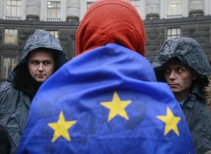 A protester wrapped in a European Union flag confronts two riot policemen guarding Ukrainian cabinet of ministers building in Kyiv on Monday, the fourth day of protests. Photo: Reuters: Gleb Garanich