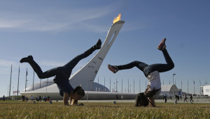 Winter Olympics? Girls in Sochi practice cartwheels on grass in front of the Olympic Flame on Feb. 12. Photo: AP/Darron Cummings
