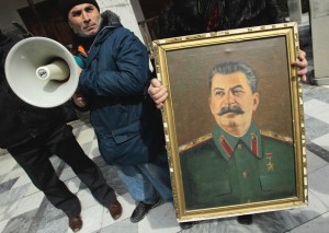 Женщина держит потрет Сталина у дома, в грузинском городе Гори. Десятки грузинских коммунистов собрались здесь 5 марта в 59-ю годовщину его смерти. Фото: Reuters, Давид Мдзинаришвили