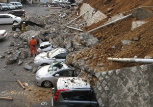 Vehicles are crushed by a collapsed wall at a carpark in Mito city in Ibaraki prefecture after a massive earthquake rocked Japan, March 11, 2011 - (Photo: AFP)