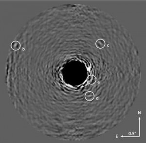 Image of the HR8799 planets with starlight optically suppressed and data processing conducted to remove residual starlight. The star is at the center of the blackened circle in the image. The four spots indicated with the letters b through e are the planets. (Image: Project 1640)