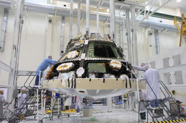NASA engineers finish their installation of the Orion spacecraft’s heat shield.  The heat shield will help protect those who ride back to Earth aboard the Orion from the blazing hot temperatures – about 2,205° Celsius - it will endure during its reentry into Earth’s atmosphere. June 5, 2014 (NASA)