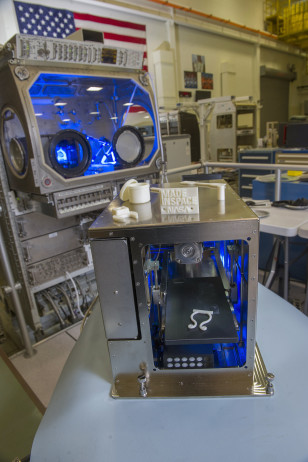 3-D printer that will soon be delivered to the International Space Station. Items the 3-D printer created is perched on its top side. (NASA)