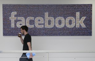 FILE - Facebook employee walks past a sign at company headquarters in Menlo Park, California. (AP)