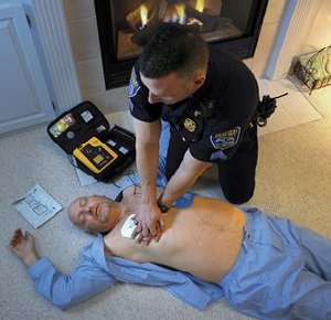 An EMS technician performs CPR on a cardiac arrest patient.  Behind patient is an automated external defibrillator (AED) which is also used to help stop ventricular fibrillation (David Bruce Jr./Creative Commons)