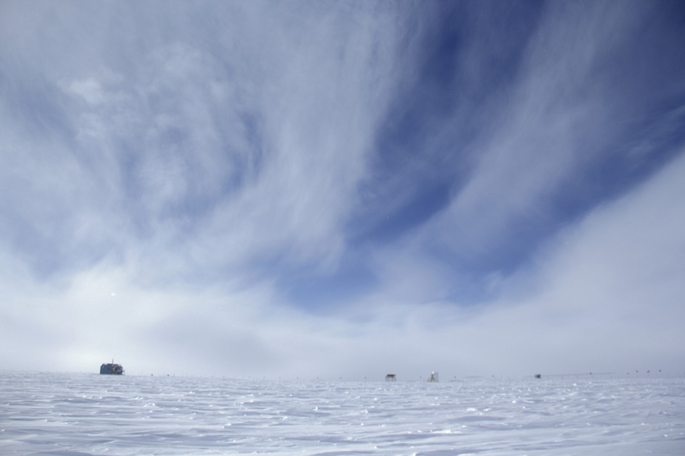 A vast, empty landscape  surrounds the Atmospheric Research Observatory (ARO) at the South Pole. The upwind side of the station (left) is the clean air sector. (Photo by Hunter Davis)