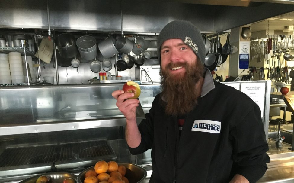 Bill Lindman, the South Pole Station's winter water plant manager, enjoys his first piece of fresh fruit of the year.