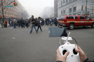 Brian Wilson flies a camera near the scene where two buildings were destroyed in an explosion, in the East Harlem section in New York City, March 12, 2014. (Reuters)