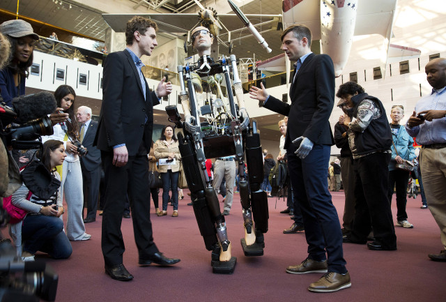 Dr. Bertholt Meyer (R) and James Pope assist the robot, "The Incredible Bionic Man," while it walks at the Smithsonian National Air and Space Museum in Washington. (Reuters)