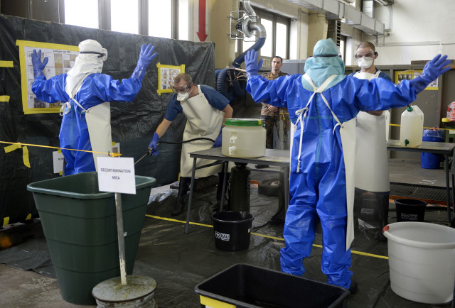 Volunteers of German army Bundeswehr, wearing protective suits, are decontaminated during an Ebola training session at the Marseille barracks in Appen, Oct. 23, 2014. (Reuters)