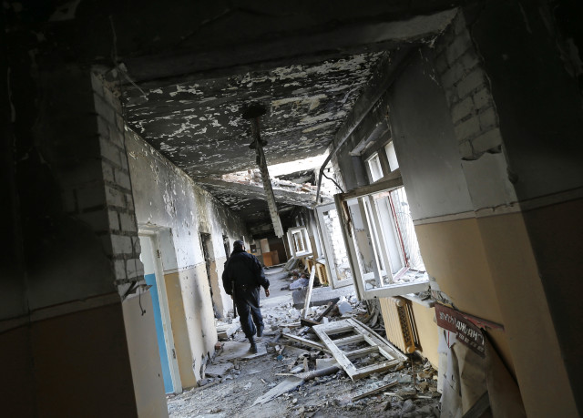 A man walks through a passageway of a mental hospital destroyed during heavy fighting between Ukrainian army and pro-Russian rebels in June in the village of Semyonovka, near the eastern Ukrainian city of Slaviansk, Sept. 28, 2014. (Reuters)