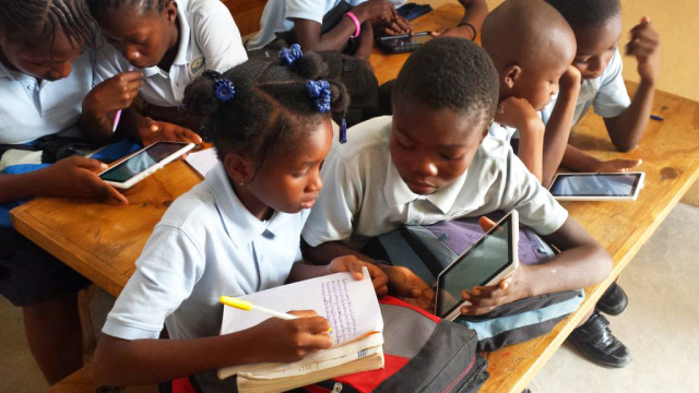 Two students at a school in Gressier, Haiti who have a five-month library access, use the library in class for a lesson. (Maritza Chateau and Amanda Truxillo)