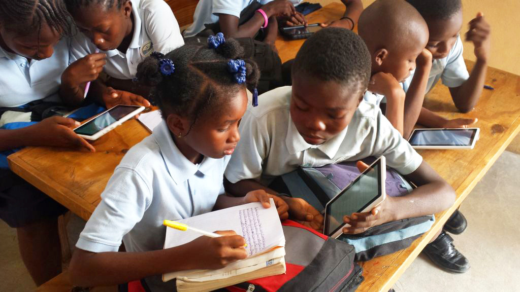 Two students at a school in Gressier, Haiti, who have a five-month library access, use the library in class for a lesson. (Maritza Chateau and Amanda Truxillo)