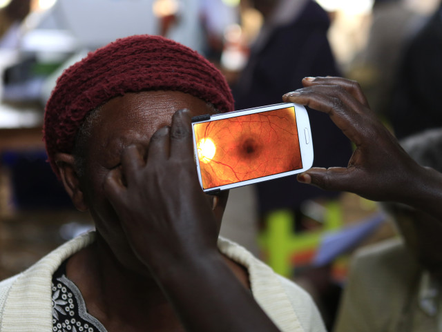 A woman undergoes an eye examination using of a smartphone at a temporary clinic by International Center for Eye Health at Olenguruone in the Mau Summit, west of Kenya's capital Nairobi, Oct. 29, 2013. (Reuters)