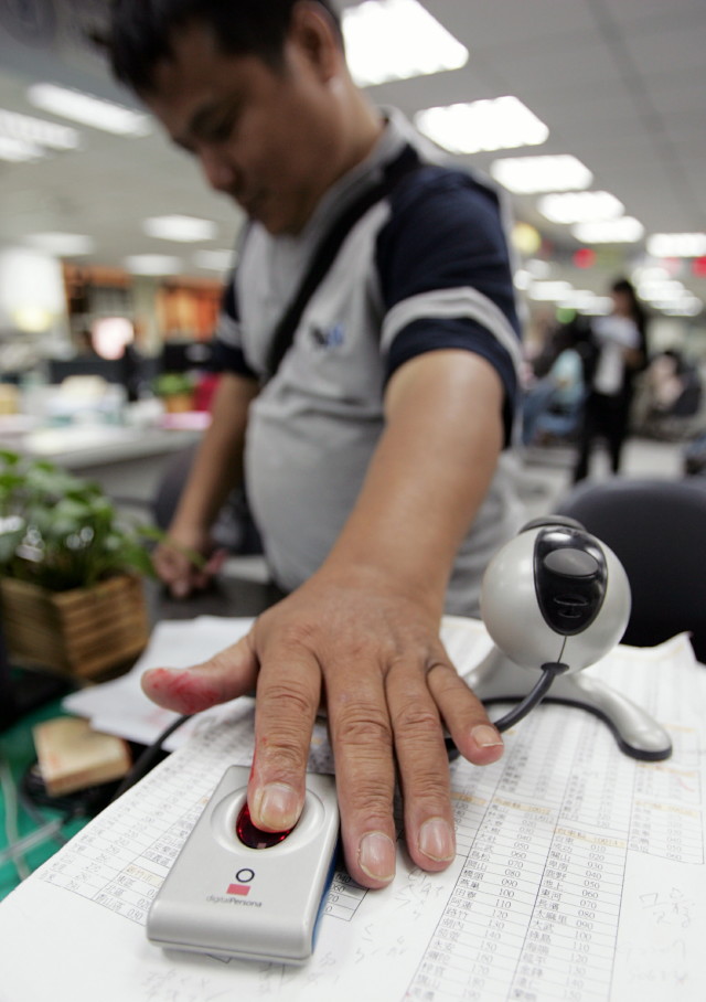 A man has his fingerprint scanned at a Taipei household registration office in Taiwan, June 17, 2005. (Reuters)