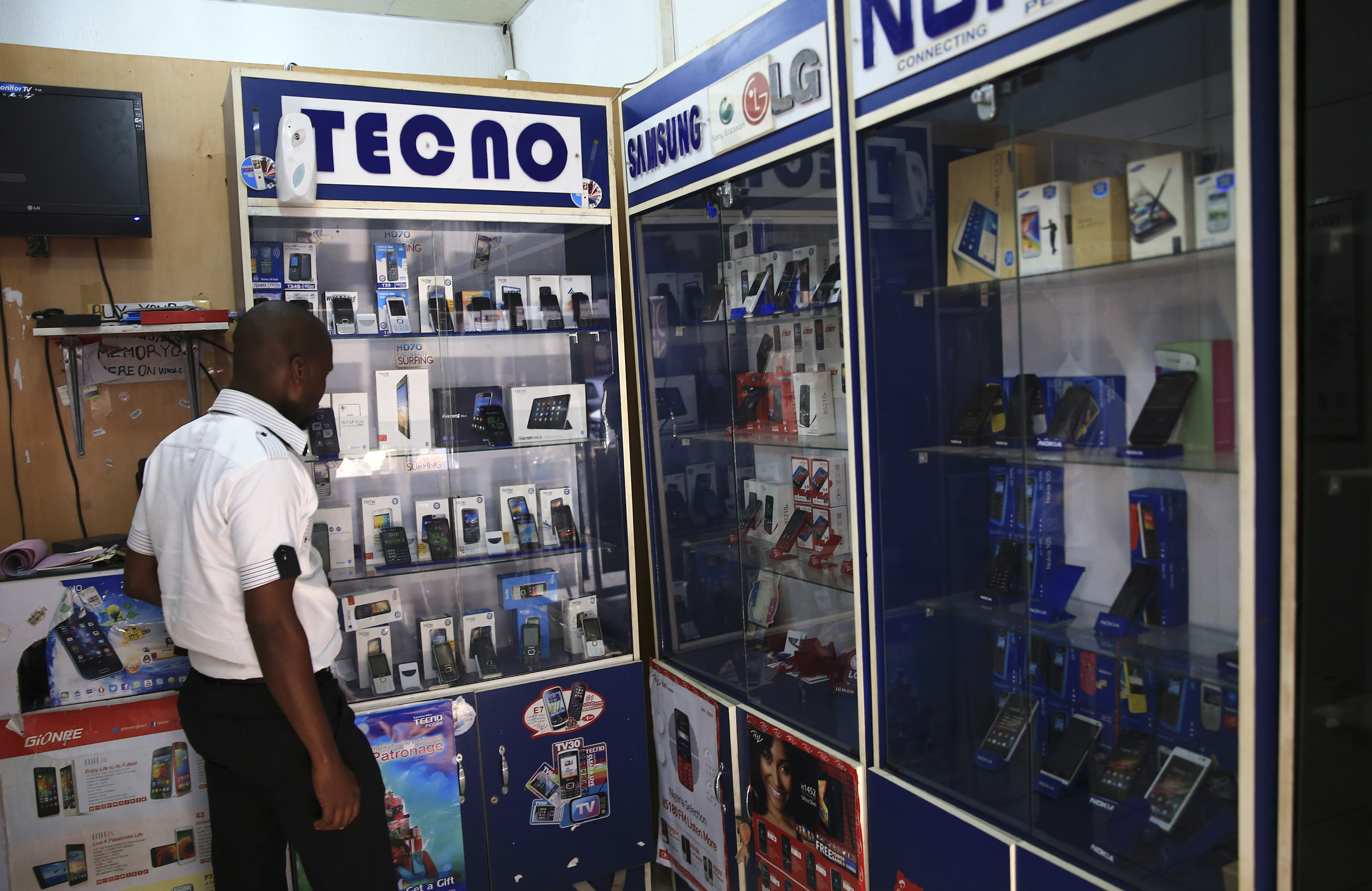 A man looks at smartphones on display at a shop at Wuse II business district in Abuja, Nigeria, Dec. 9, 2014. (Reuters)